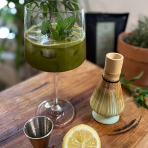 Coctailglas mit Matcha Getränk und Minzblatt
